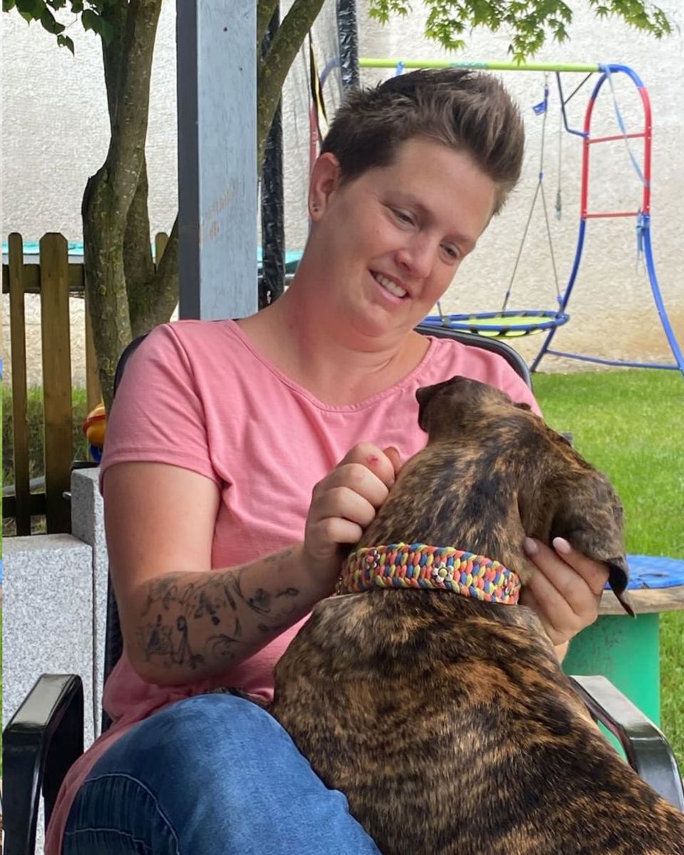 Sabrina lacht und krault Loraine im Garten